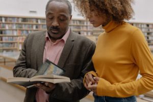 Two people looking at a book together